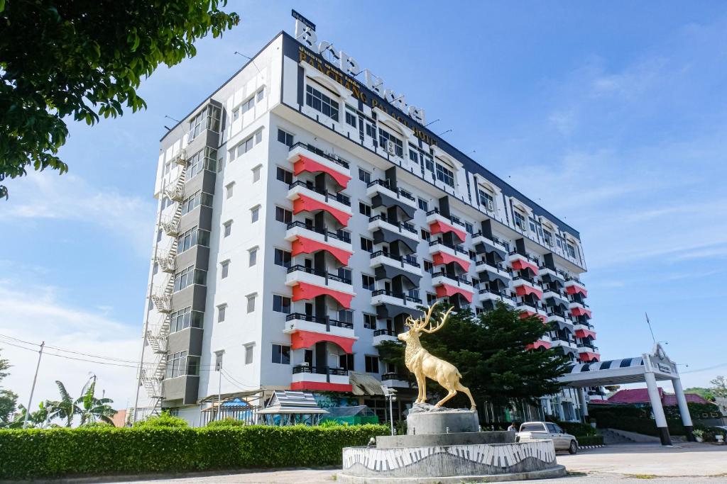 una estatua de jirafa delante de un edificio en BCP Hotel en Ban Chang