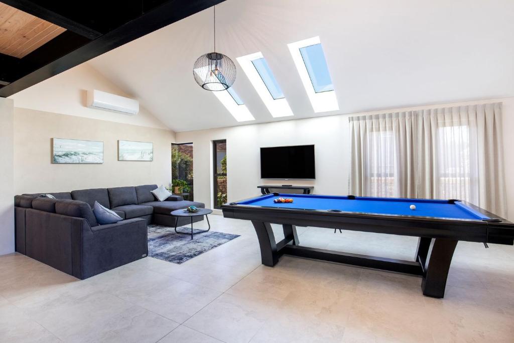 a living room with a pool table and a couch at Eclipse Absolute Beachfront with Stunning Views in Culburra Beach