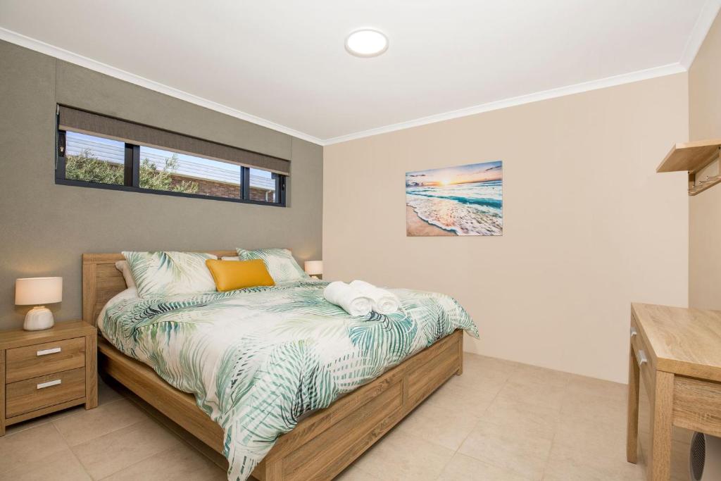a bedroom with a bed and a desk at Eclipse Absolute Beachfront with Stunning Views in Culburra Beach