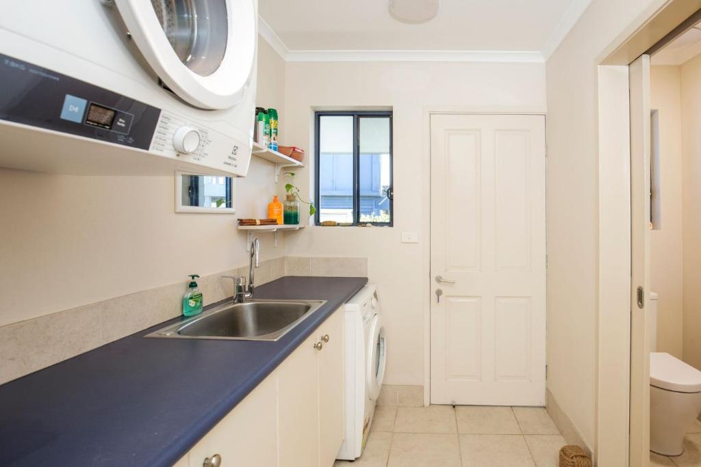 a kitchen with a sink and a microwave at Eclipse Absolute Beachfront with Stunning Views in Culburra Beach