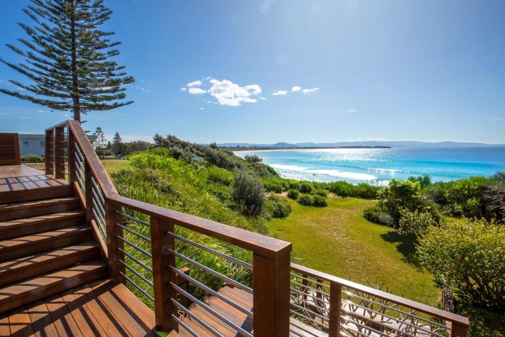 a wooden deck with a view of the ocean at Eclipse Absolute Beachfront with Stunning Views in Culburra Beach