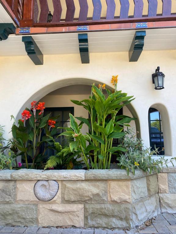 a stone retaining wall with flowers on a building at TIDE POOL VILLAS in Santa Barbara