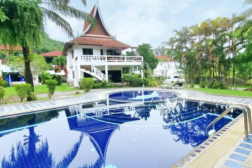 una piscina frente a una casa con un edificio en Lovely 2-Bedroom Condo with Pool, en Kamala Beach
