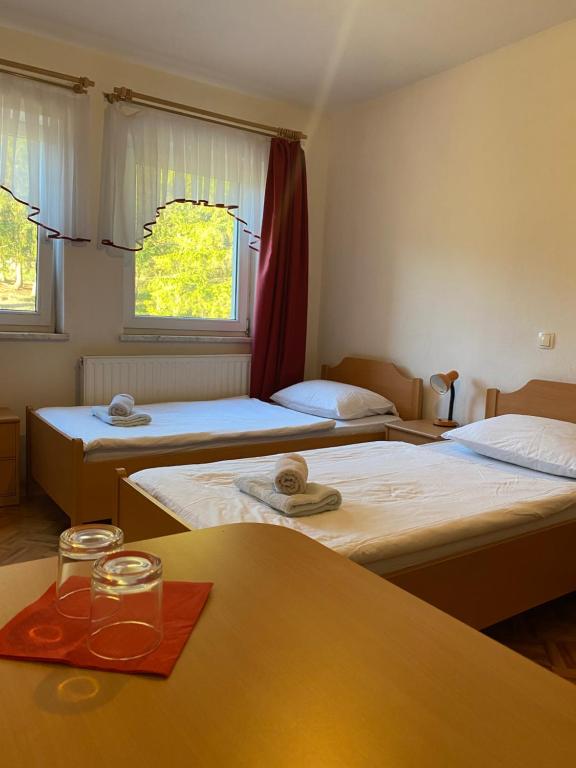 una habitación con 3 camas y una mesa con gafas en KMETIJA KNAVS, en Nova Vas