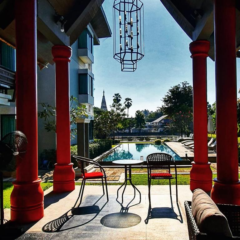 A covered patio with café seating directly beside the resort pool.