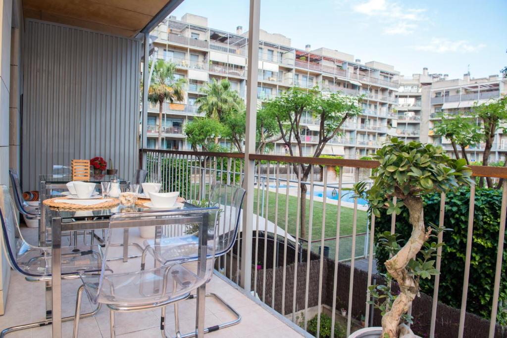 巴塞隆納的住宿－奧朋寧多爾斯普柏洛紐奧沃公寓，一个带桌椅的阳台和一座建筑