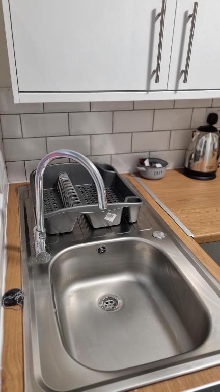 a kitchen sink with a dish drying rack next to it at L.F.C Townhouse in Anfield in Liverpool