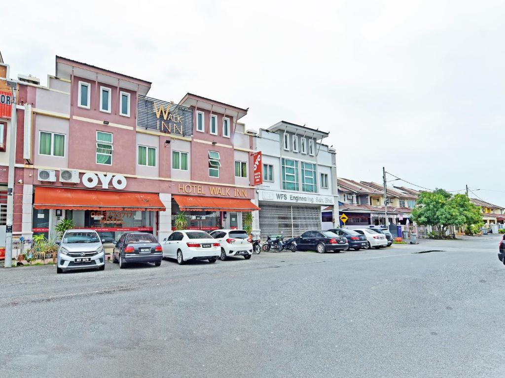 una calle de la ciudad con coches estacionados frente a los edificios en OYO 582 Hotel Walk Inn, en Melaka