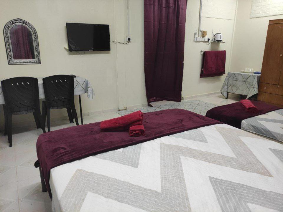 a bedroom with a bed and a tv on the wall at CiTY Roomstay Budget Midtown Kuala Terengganu 2queen beds in Kuala Terengganu