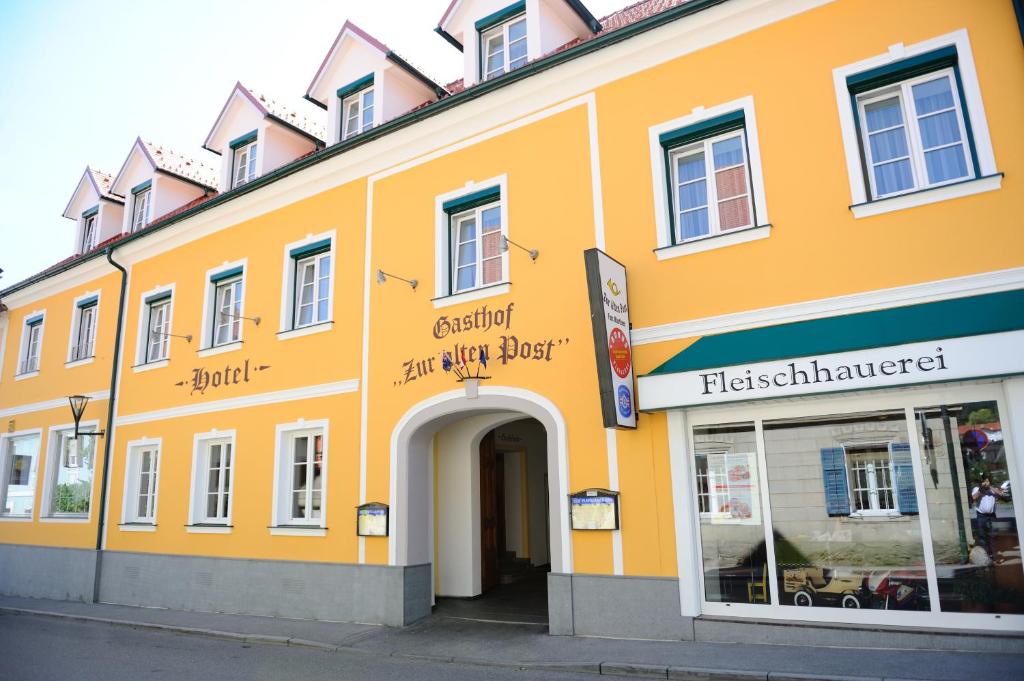 a large orange building with an entry way at Hotel-Gasthof-Fleischerei - Zur alten Post in Schwanberg