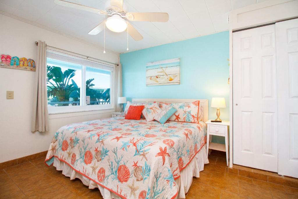 - une chambre avec un lit, une fenêtre et un ventilateur de plafond dans l'établissement Tropic Terrace #31 - Beachfront Rental condo, à St. Pete Beach
