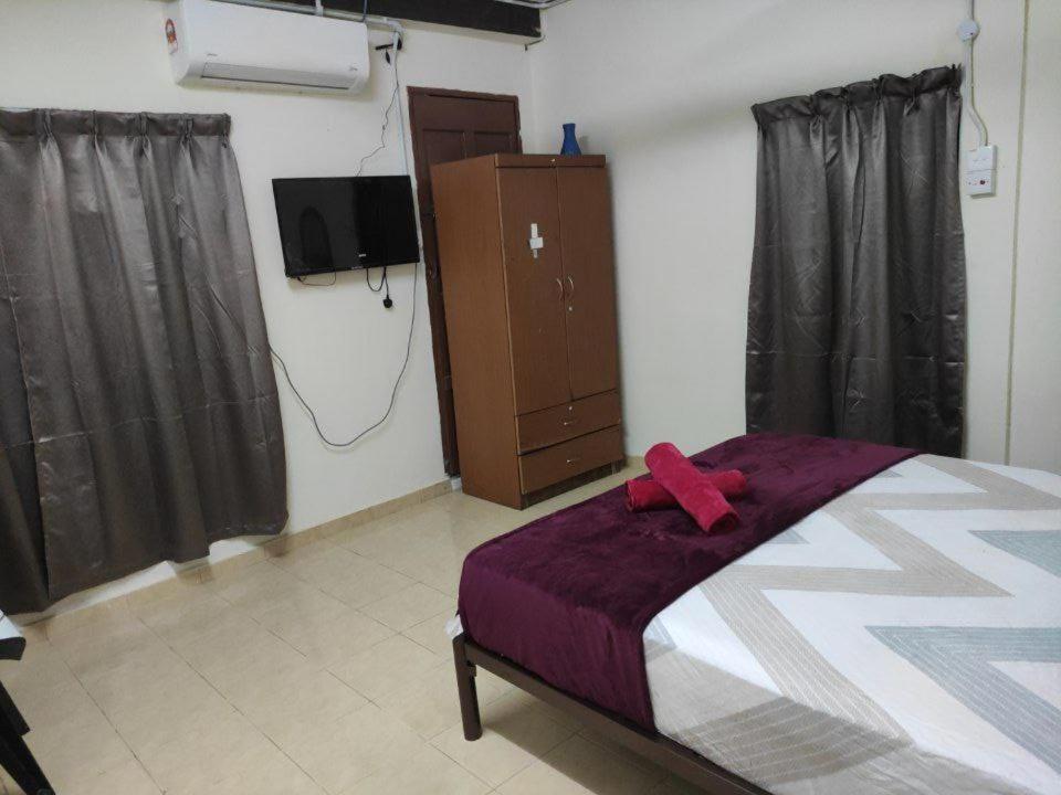 a bedroom with a bed with a red ribbon on it at CiTY Roomstay Budget Middle Kuala Terengganu 1queen bed in Kuala Terengganu