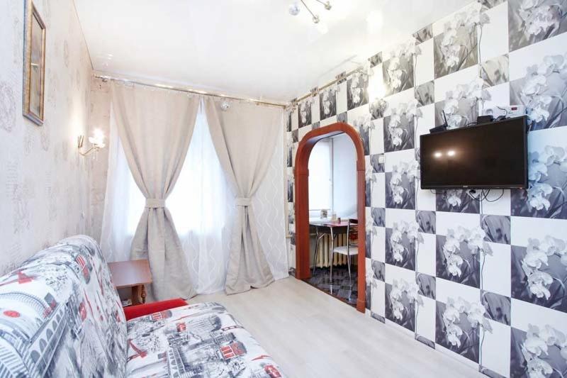 Zimmer mit einem TV an der Wand mit Bildern darauf in der Unterkunft ROTAS On Moskovsky 165 in Sankt Petersburg