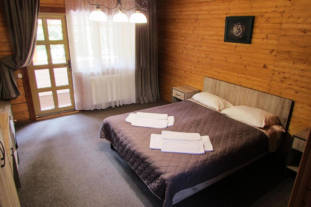 1 dormitorio con 1 cama con 2 toallas en Екосадиба Водограй, en Kvasy
