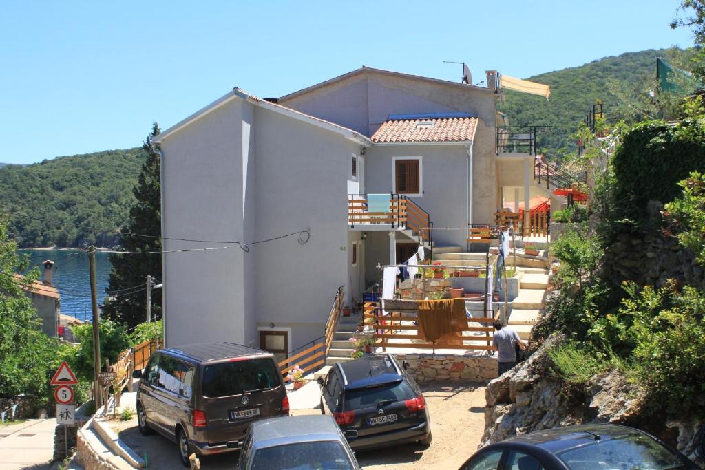 a house with cars parked in front of it at Apartments by the sea Valun, Cres - 8081 in Valun