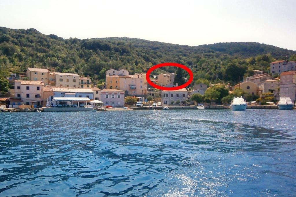 a red circle in the middle of a body of water at Apartments by the sea Valun, Cres - 8086 in Valun