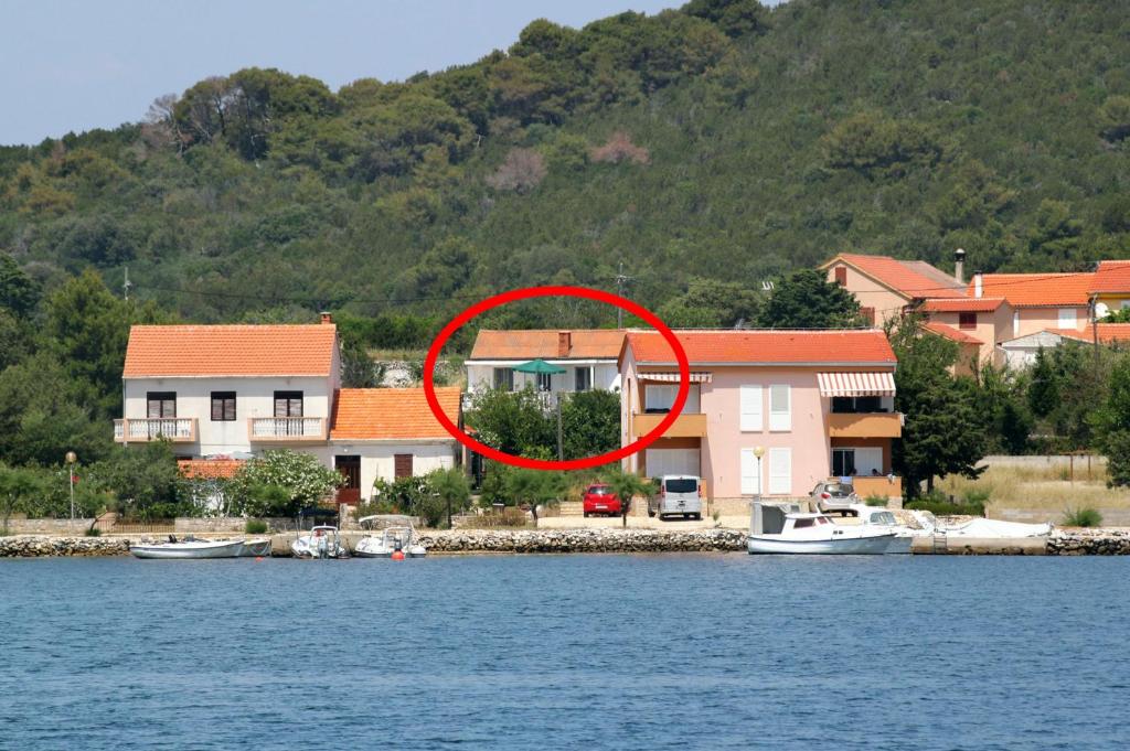 a house on the shore of a body of water at Apartment Verunic 8104a in Veli Rat