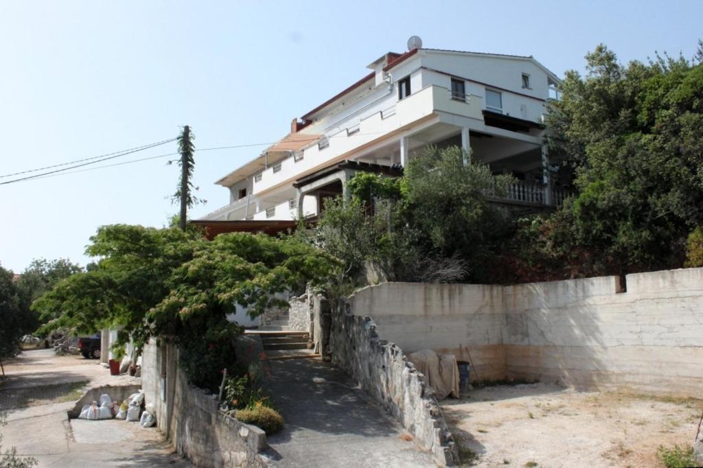 uma casa branca em cima de uma parede de retenção em Twin Room Luka 8132e em Žman