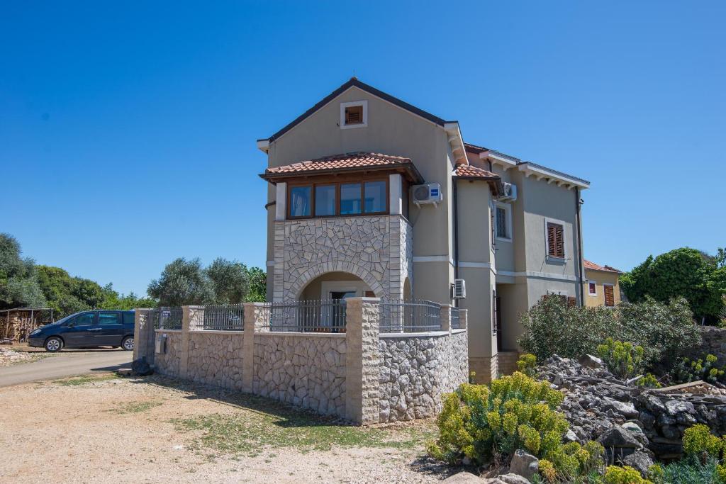 a large house with a stone wall at Apartments with a parking space Punta kriza, Cres - 8082 in Punta Križa