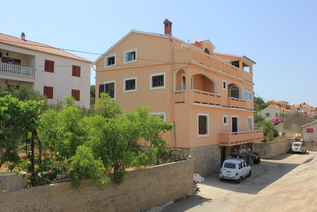 a building with a car parked in front of it at Apartments by the sea Sali, Dugi otok - 8121 in Sali