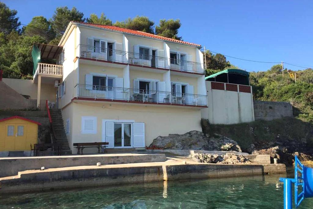 a house on a hill next to the water at Apartments by the sea Savar, Dugi otok - 8079 in Brbinj