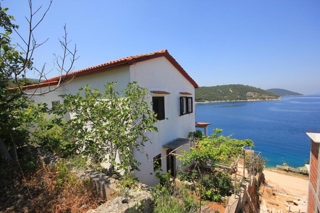 a white house on a hill overlooking the ocean at Apartments by the sea Savar, Dugi otok - 8080 in Brbinj