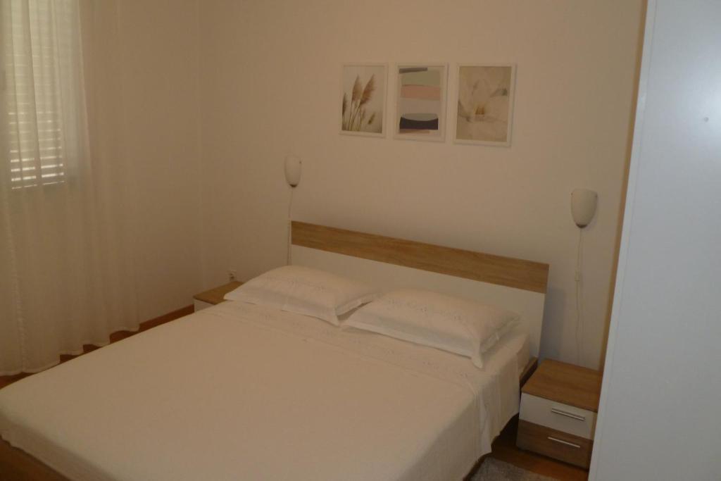 1 dormitorio con 1 cama blanca y 2 almohadas blancas en Apartments with a parking space Sali, Dugi otok - 8154 en Sali