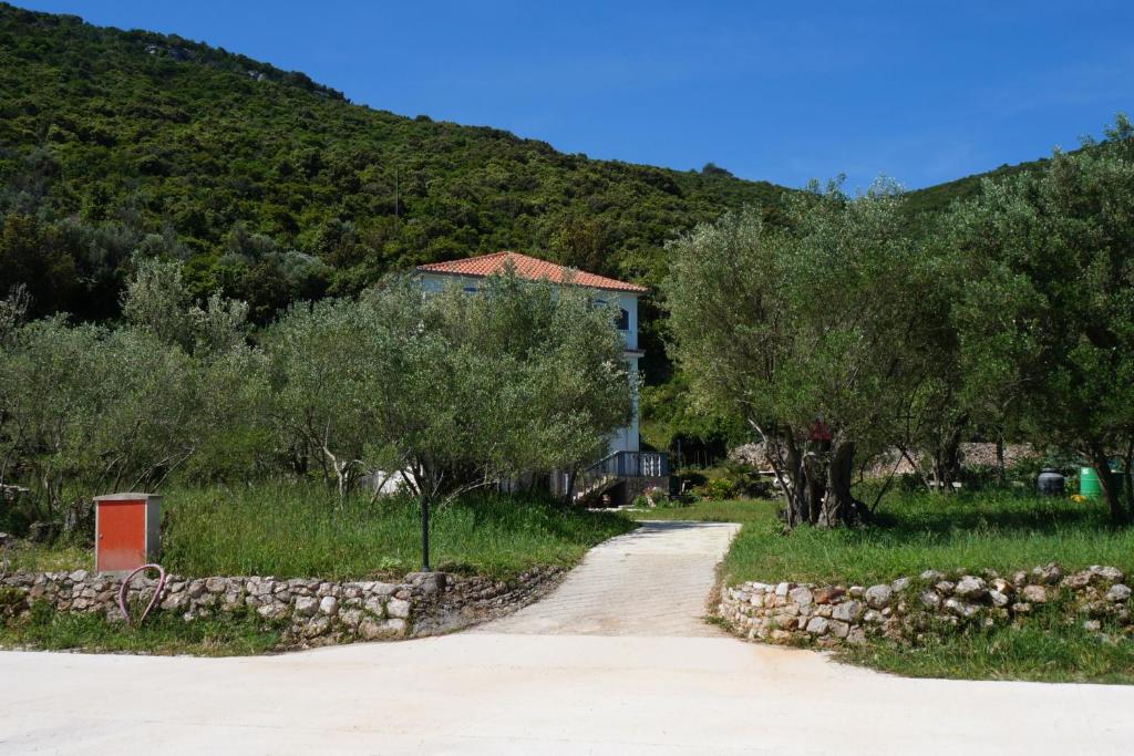 uma estrada de terra em frente a uma casa com árvores em Apartments by the sea Luka, Dugi otok - 8151 em Luka
