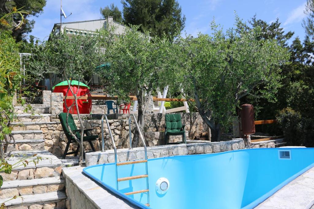 a pool in a yard with trees and a house at Family friendly apartments with a swimming pool Okrug Donji, Ciovo - 8072 in Okrug Donji