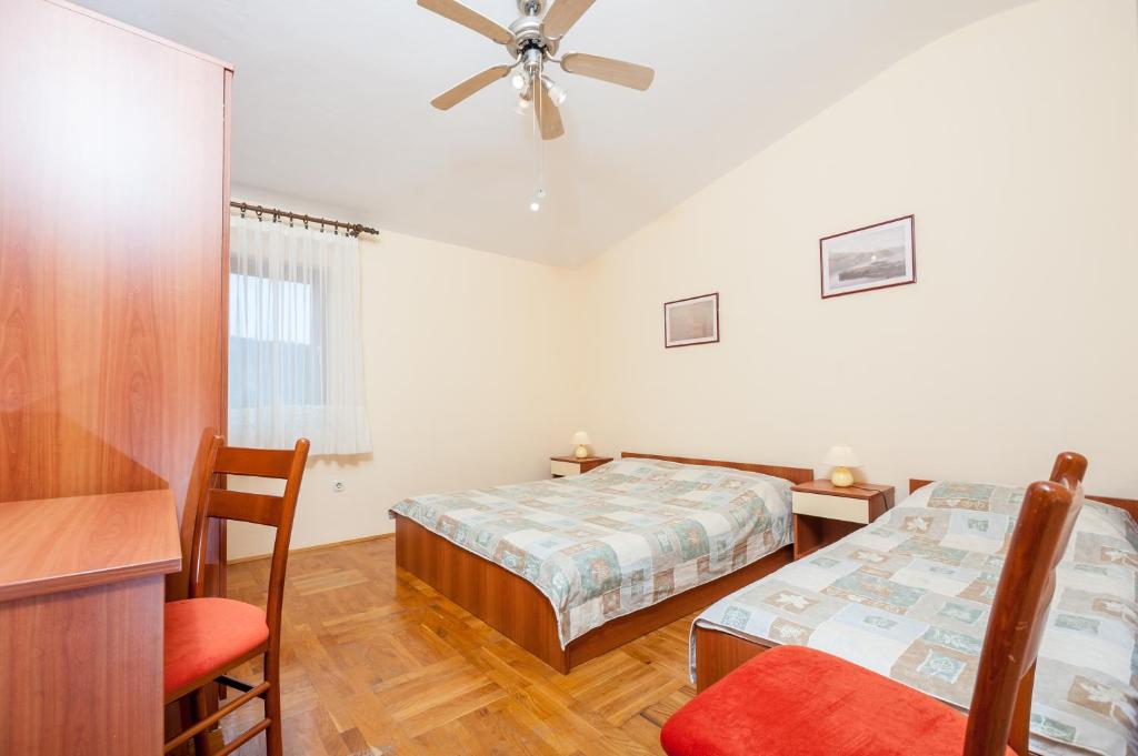 a bedroom with two beds and a ceiling fan at Apartments with a parking space Bozava, Dugi otok - 8124 in Božava