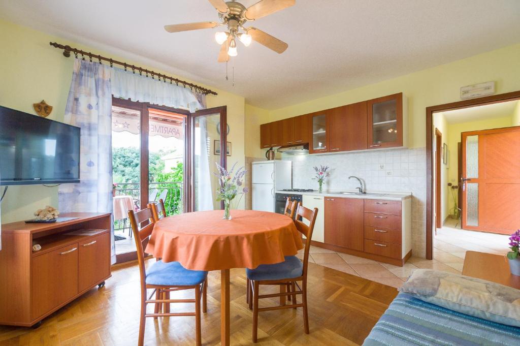 a kitchen and dining room with a table and chairs at Apartments with a parking space Bozava, Dugi otok - 8124 in Božava