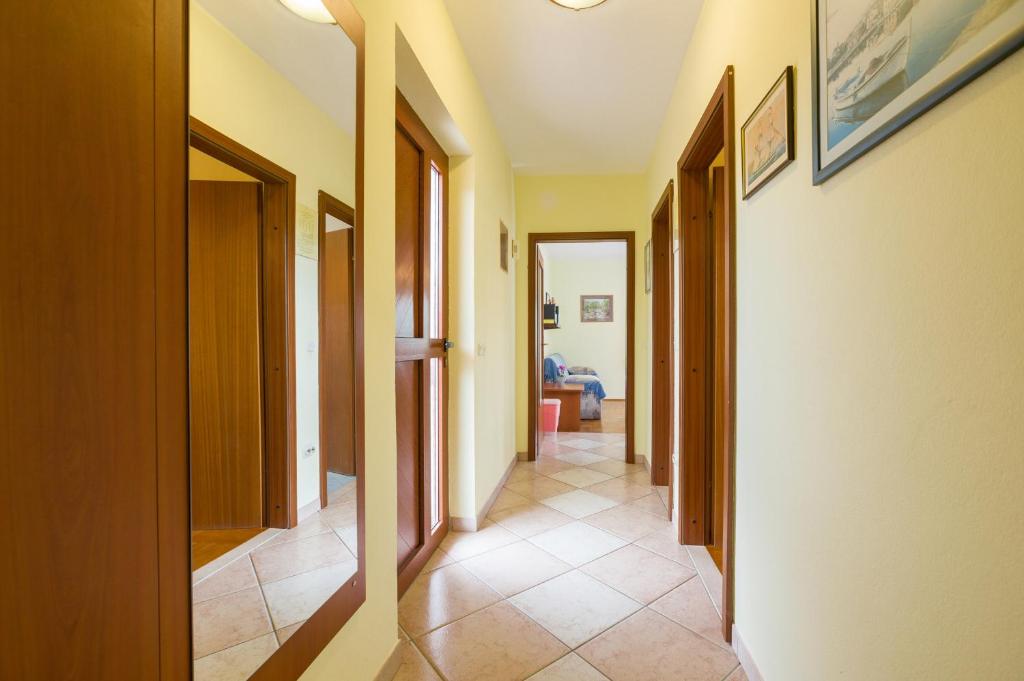a hallway with many doors and a tile floor at Apartments with a parking space Bozava, Dugi otok - 8124 in Božava