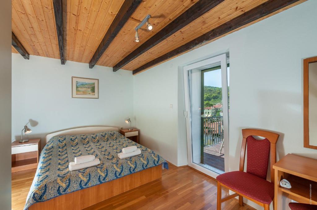 a bedroom with a bed and a chair and a window at Apartments with a parking space Bozava, Dugi otok - 8124 in Božava