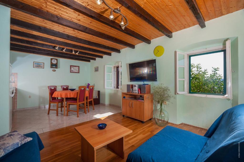 a living room with a blue couch and a table at Apartments with a parking space Bozava, Dugi otok - 8124 in Božava