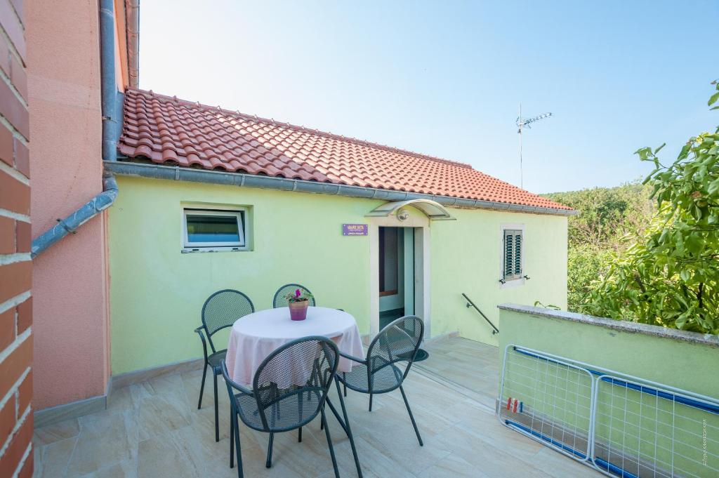 a table and chairs on the balcony of a house at Apartments with a parking space Bozava, Dugi otok - 8124 in Božava