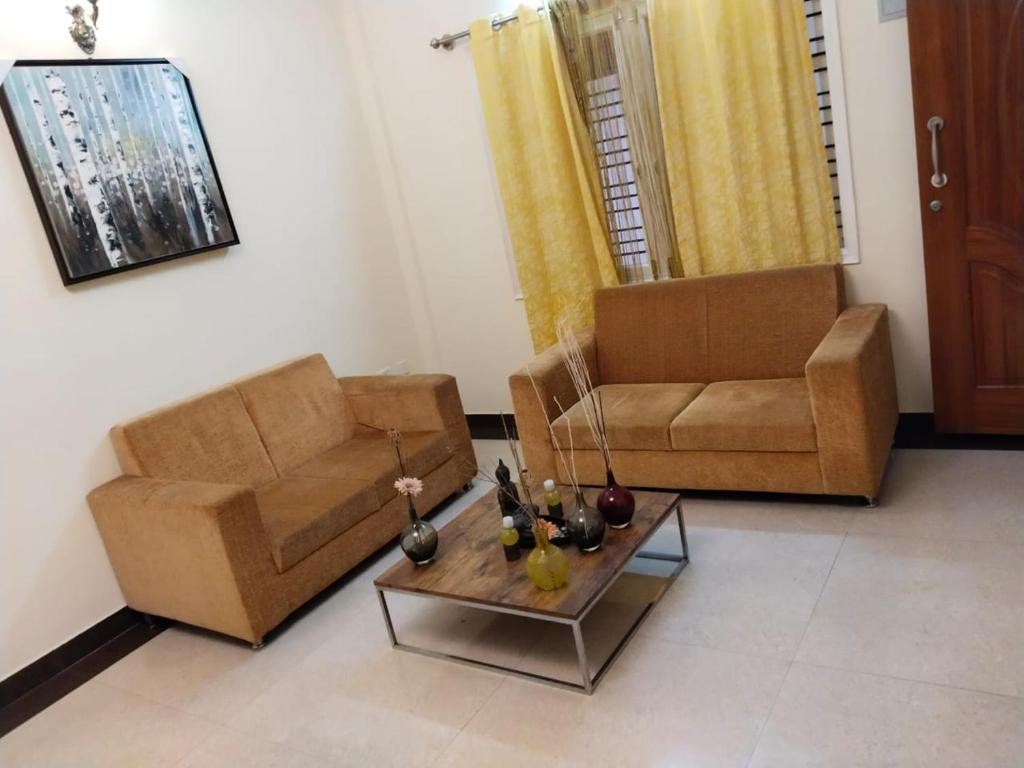 a living room with two couches and a coffee table at HOTEL SLN Homes in Bangalore