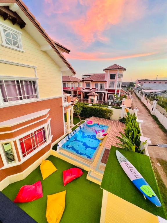 a backyard with a swimming pool and a house at Landara Private Pool Villa Sattahip in Sattahip