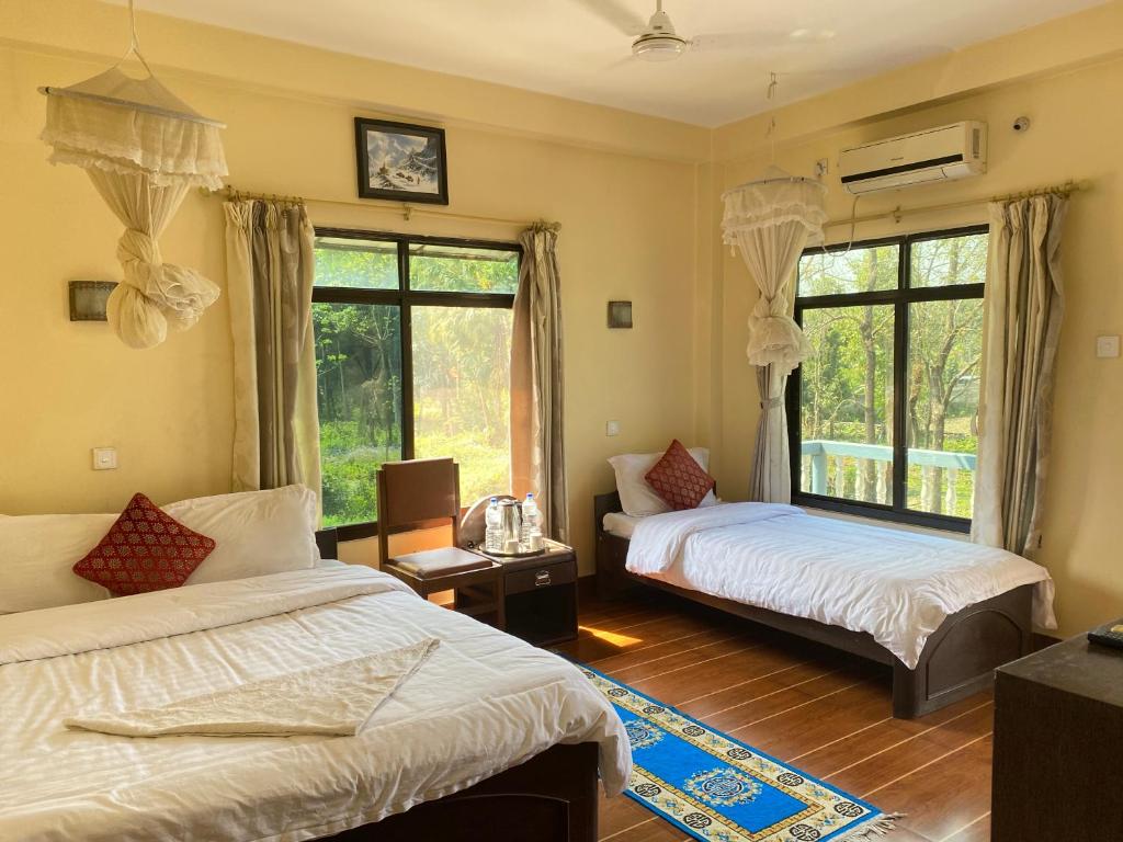 1 dormitorio con 2 camas y ventana en Peacock - a family-run hotel, en Sauraha