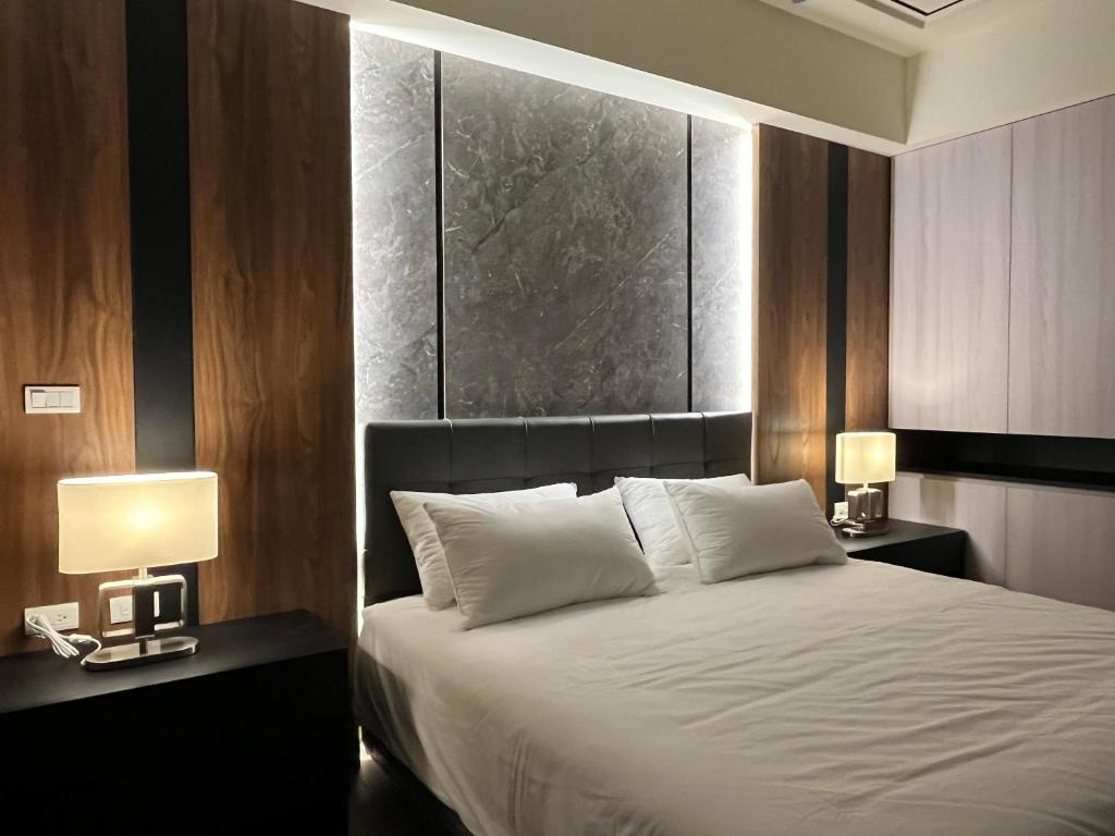 a bedroom with a bed with two nightstands and two lamps at Lin House in Checheng