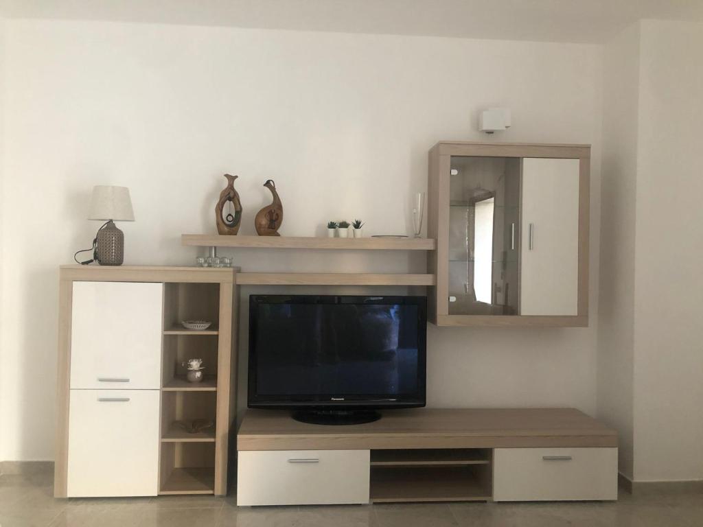 a living room with a tv and a mirror at Casa Sofia in Marconia