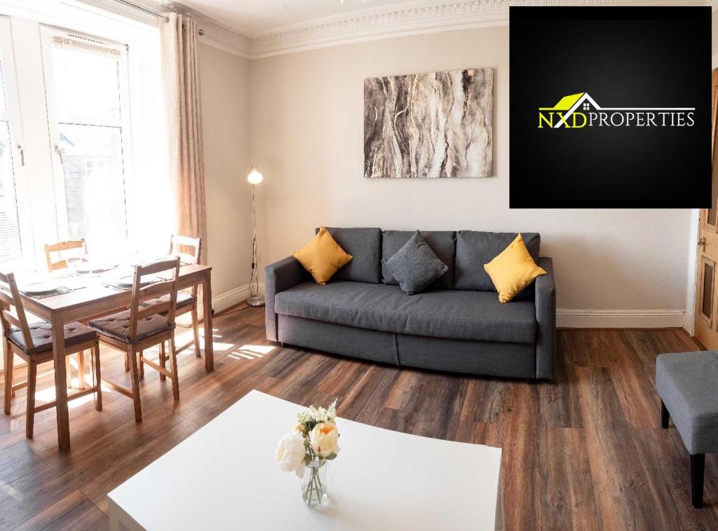 uma sala de estar com um sofá e uma mesa em Bright, Spacious West-End Flat, Near University em Dundee
