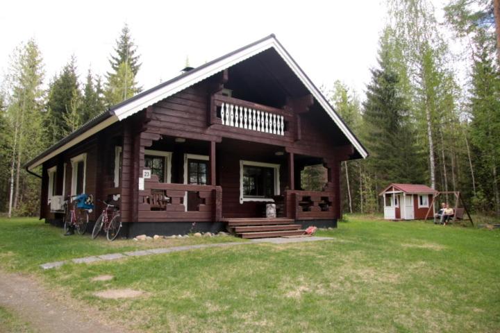 eine große Holzhütte in der Mitte eines Feldes in der Unterkunft Pohjantilan Hirsituvat - Pohjantähti in Kontiolahti