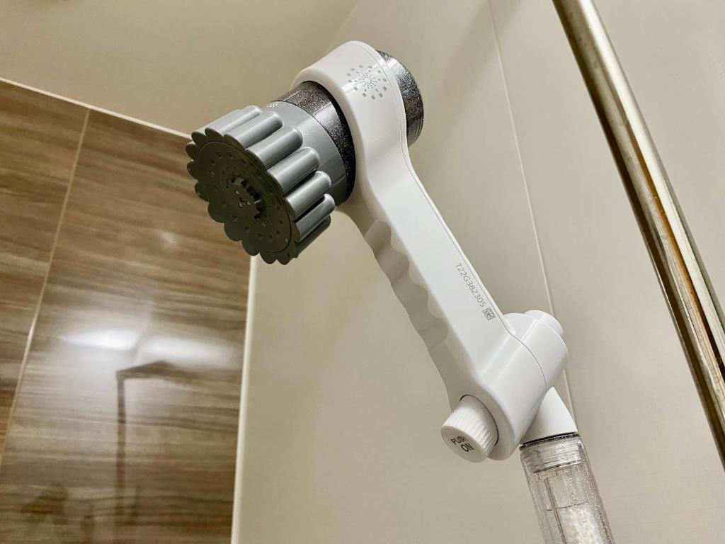 a white electric toothbrush hanging on a wall at Villa Monica in Nagoya