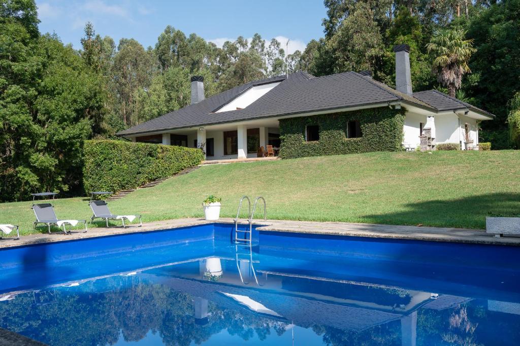 uma casa com piscina em frente a uma casa em Fidalsa Relax Inn em Urduliz