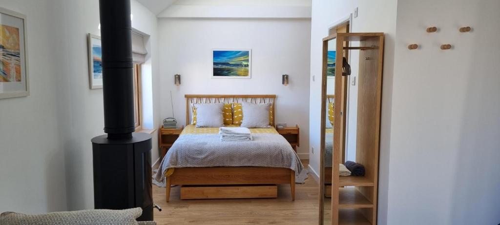 a bedroom with a bed and a wood stove at The Brookhouse. Cheerful tiny house with Seaview. in Ilfracombe