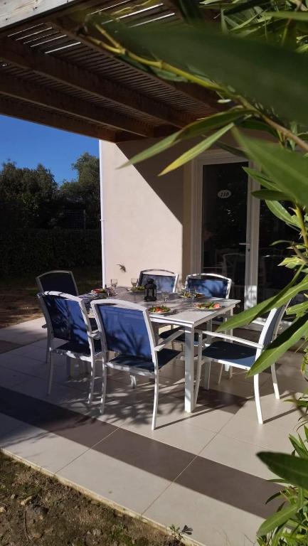 une table et des chaises assises sur une terrasse dans l'établissement Maison duplex 2 chambres, avec jardin, 800m plage, à Belgodère