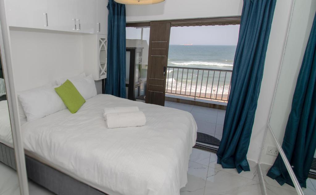 a bedroom with a bed with a view of the ocean at 8 Bronze Beach Umhlanga Rocks in Durban