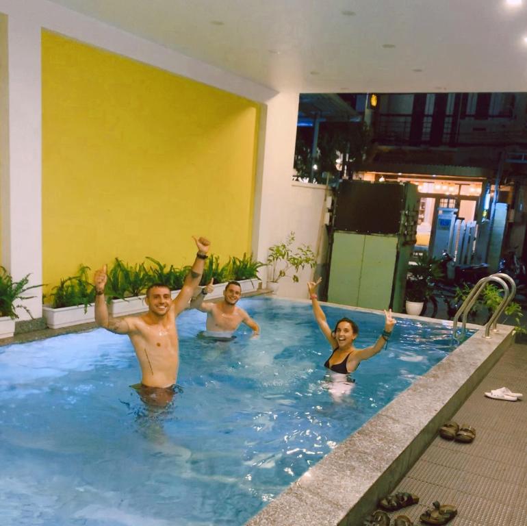 a group of people in a swimming pool at The Imperfect Downtown Hoi An in Hoi An