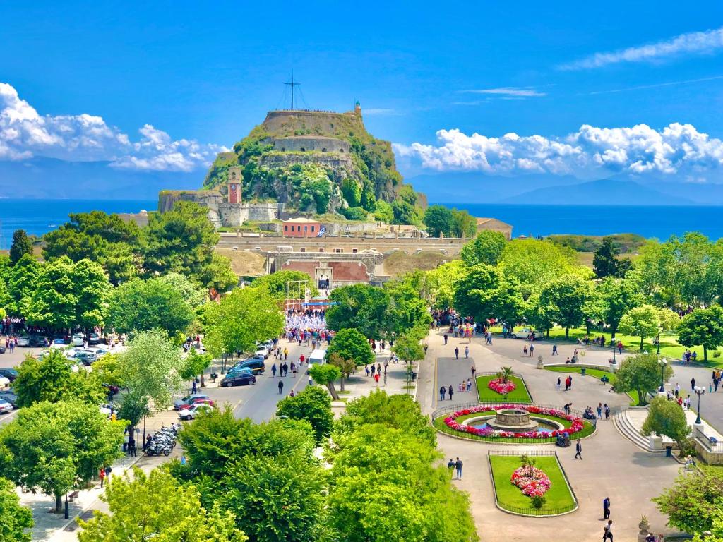 a view of a park with a hill in the background at Arcadion Hotel in Corfu Town