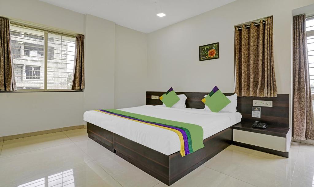 Säng eller sängar i ett rum på Treebo Trend Excellent Homes, Nashik